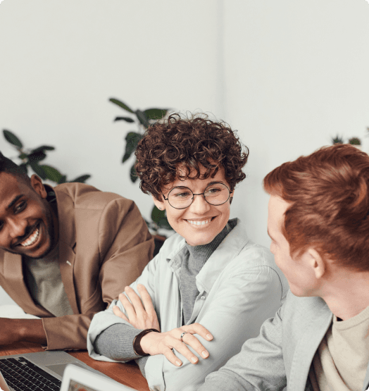 A few people in a meeting talking and smiling